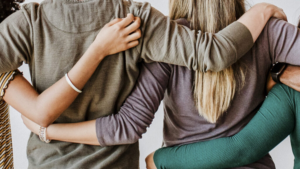 Rearview of diverse people hugging each other