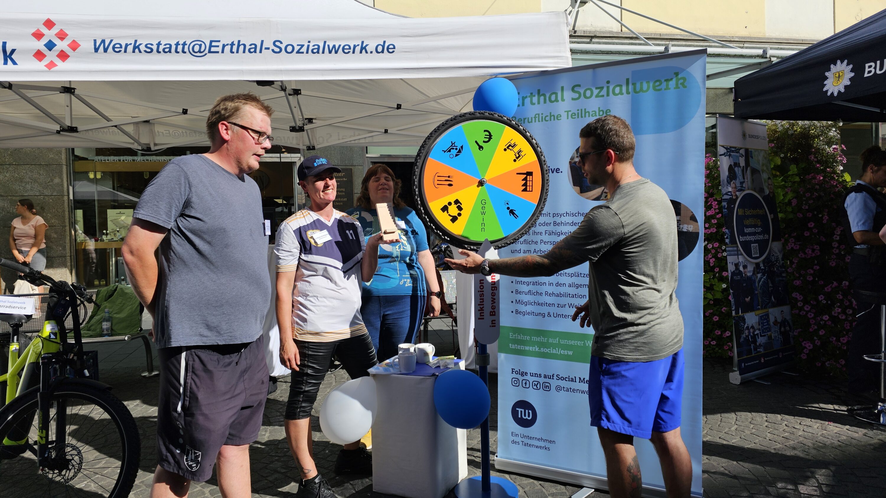 Der Stand des Erthal-Sozialwerks auf dem Stadtfest. Besucher:innen drehen am Glücksrad.