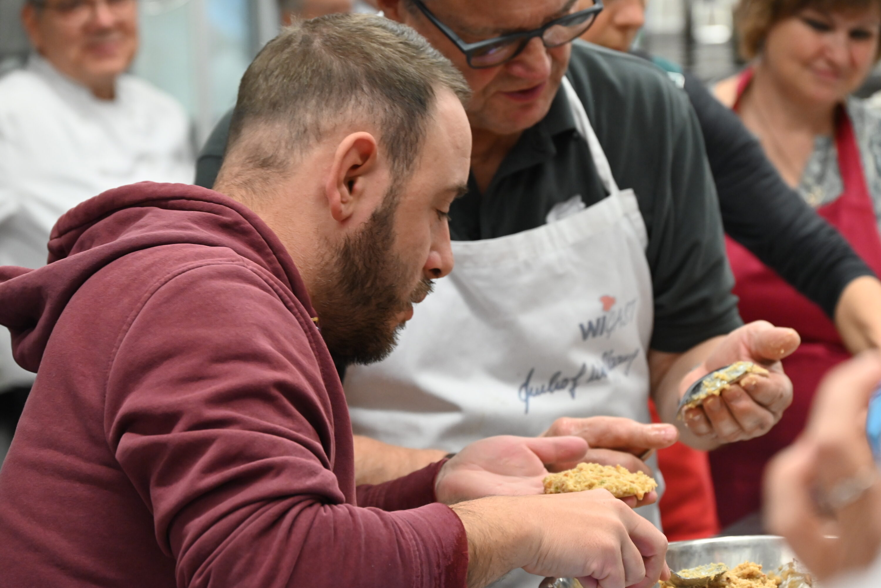 Ein Bewohner des St. Josefs-Stift lernt wie Lebkuchen geformt werden unter der Anleitung eines Kochs des Kochverein Frankonia e.V.