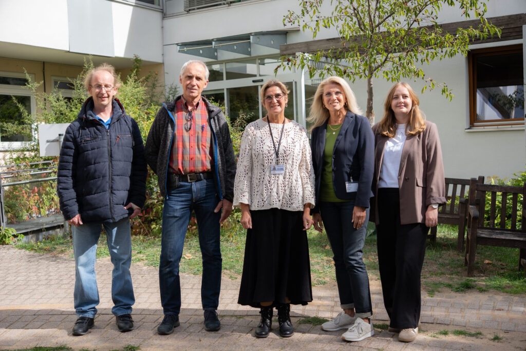 Fünf Teilnehmende des Schichtwechsels stehen vor der Kinderklinik Würzburg und lächeln in die Kamera.